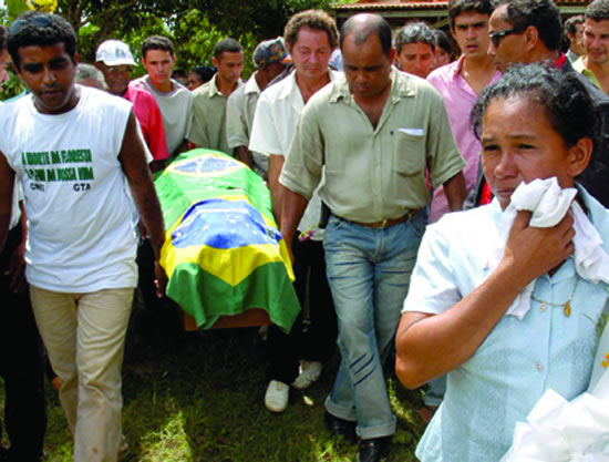 PEOPLE carry the coffin of Sister Dorothy Stang at a cemetery in Para, Brazil on February 15, 2005. Her casket is draped in a Brazilian flag.
